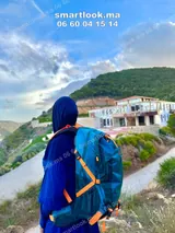 Femme portant le sac CAMEL 40L bleu en montagne au Maroc - photo réelle